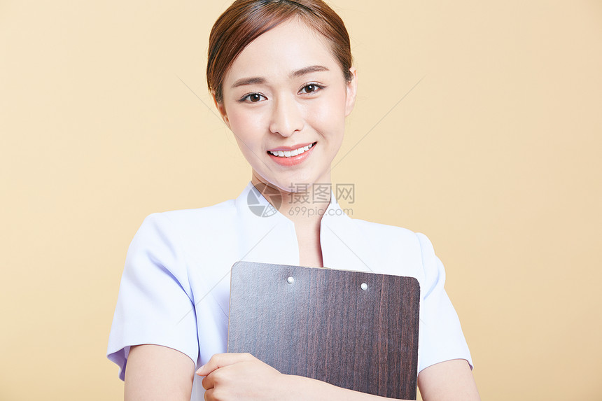 年轻护士抱着文件板微笑图片