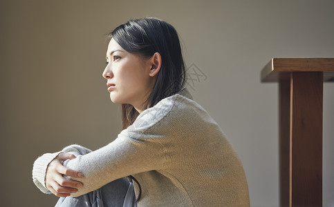 坐在地上思考的女性图片