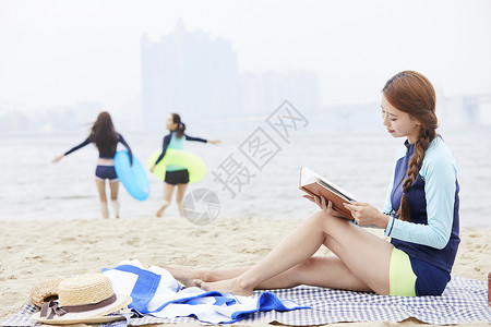 海边度假看书的年轻女子图片