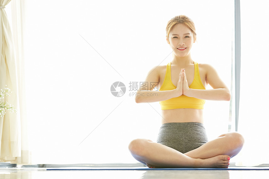 坐在瑜伽垫上的年轻女子图片
