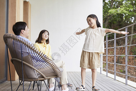 父母和女儿在阳台上休息植物高清图片素材