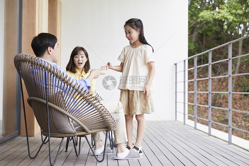 在阳台上休息玩耍的父母和女儿图片