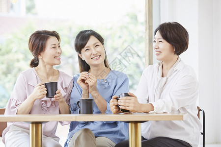 成年女子和伙伴在咖啡店享受下午茶图片