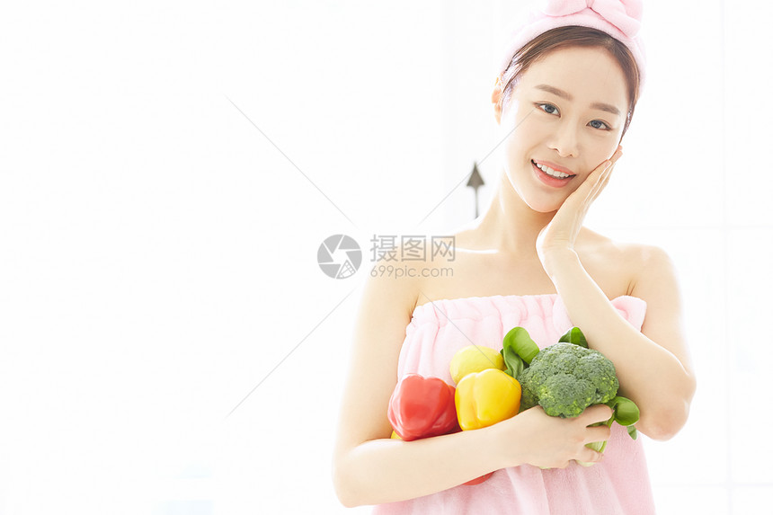 抱着蔬菜微笑的年轻女子图片