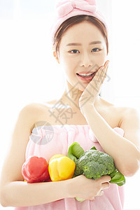 年轻女子抱着蔬菜微笑图片