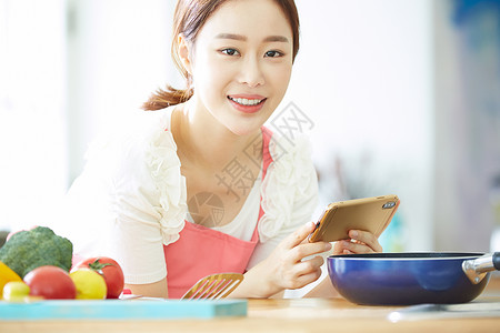 年轻女子拿着手机拍食物的照片图片