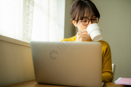 居家办公喝咖啡的年轻女性图片