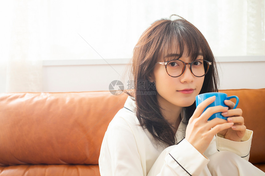 沙发上喝咖啡的居家女孩图片