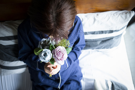 女孩抱着鲜花独自生活图片