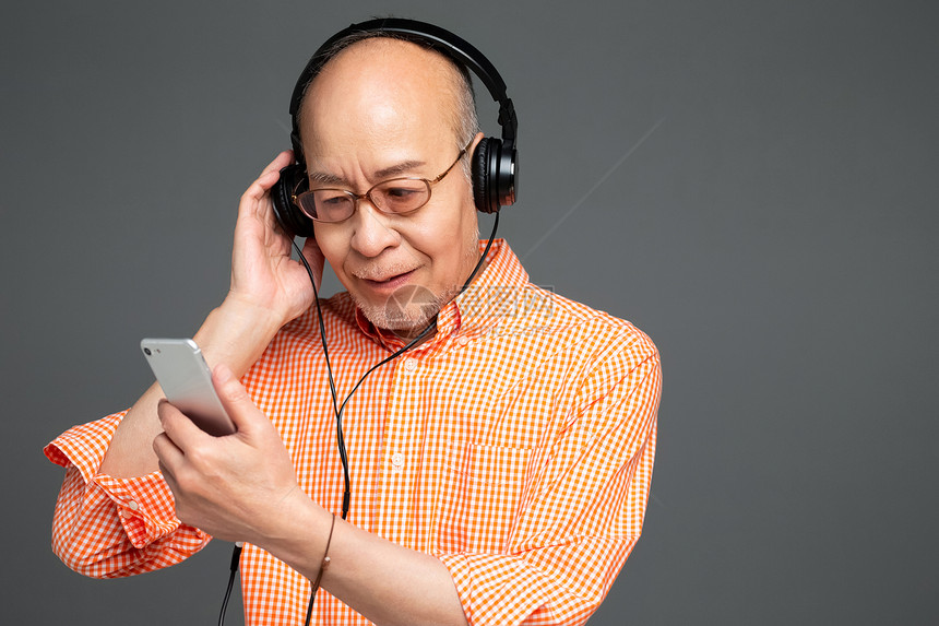 戴着耳机听音乐的老年人图片