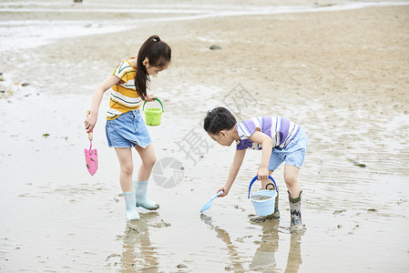 儿童在海边玩耍长靴高清图片素材