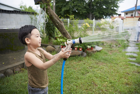 拿着水壶的男孩拿着水管玩的男孩背景