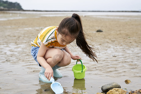 在海边捡石子的小孩实地研究高清图片素材