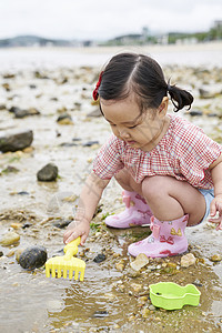 在海边捡石子的小孩笑高清图片素材