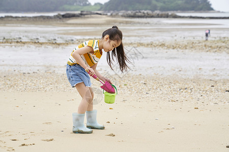 在海边捡蛤的小孩长靴高清图片素材