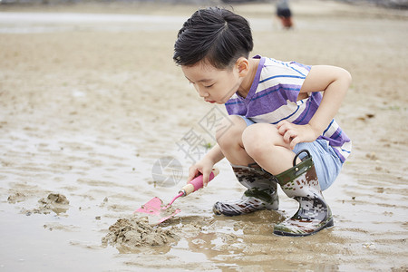 在沙滩边玩耍的儿童高靴高清图片素材