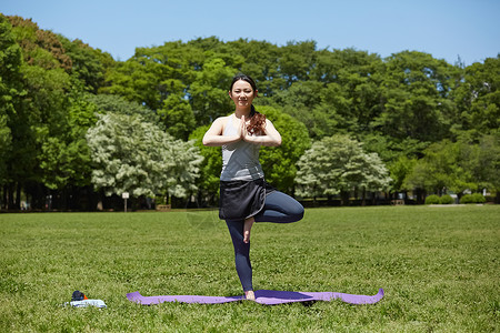 室外草地公园做瑜伽的女青年图片