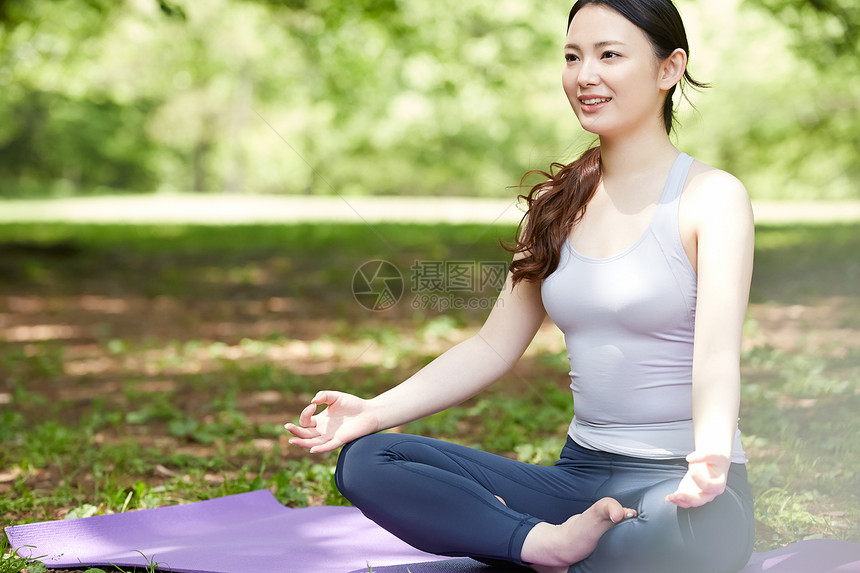 盘腿坐在瑜伽垫上的女性图片