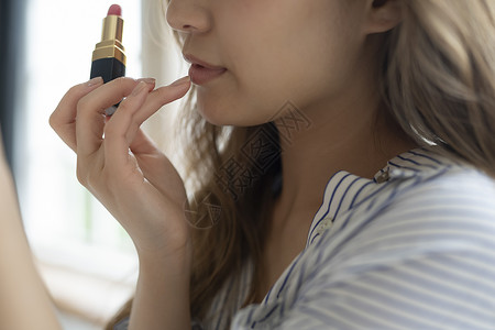 涂抹口红的女子特写图片