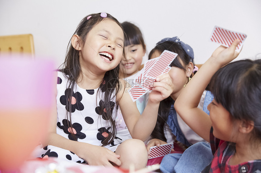 室内玩耍女孩和朋友一起玩卡片图片