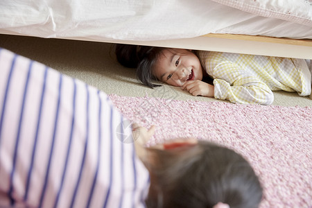 小朋友躲在床底下背景