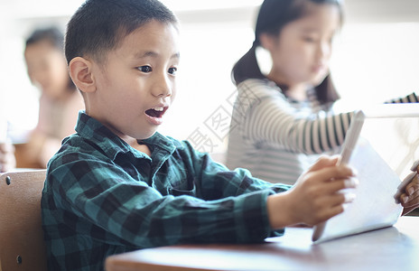 在课堂上学习平板电脑知识的小朋友教学用具高清图片素材