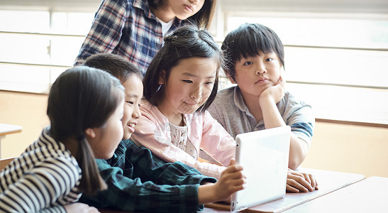 小学生使用平板电脑学习讨论图片