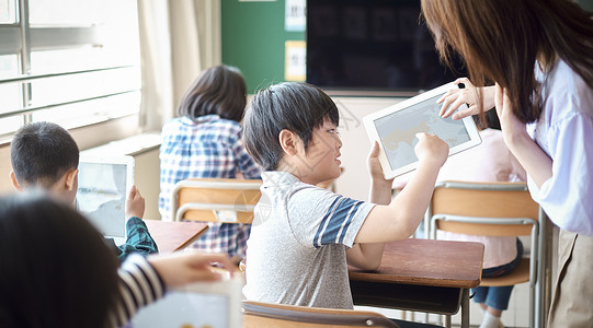 小学生在老师的指导下学习平板电脑使用知识男人高清图片素材