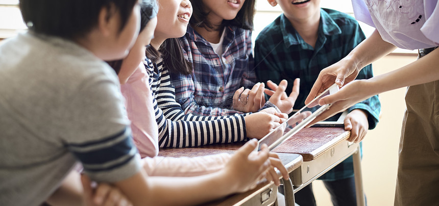 小学生在老师的指导下学习平板电脑使用知识图片