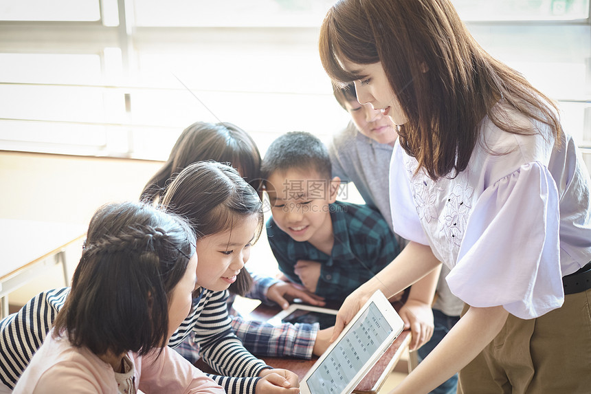 小学生在老师的指导下学习平板电脑使用知识图片