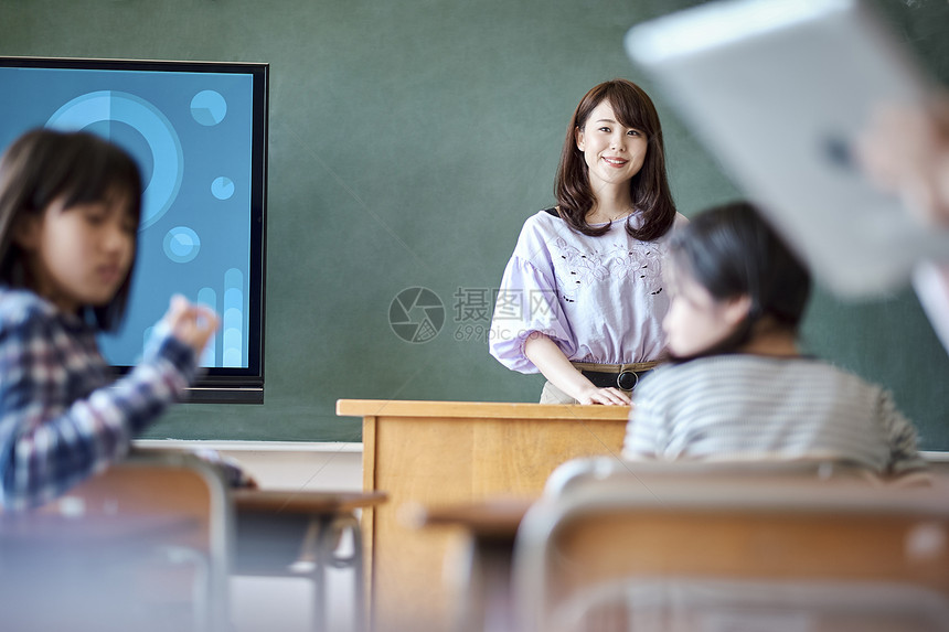 小学生在老师的指导下学习平板电脑使用知识图片