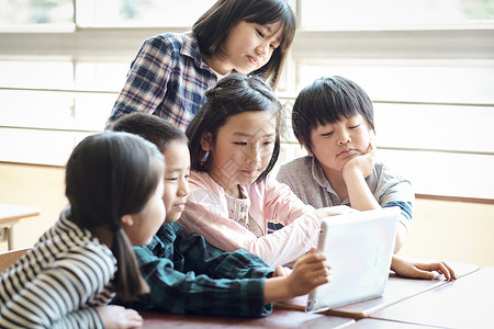 小学生使用平板电脑学习讨论背景图片