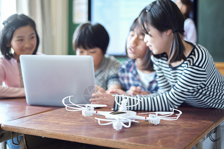 小学生在老师的指导下用电脑查询资料女生高清图片素材