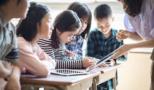 小学生在老师的指导下用电脑查询资料小姑娘高清图片素材