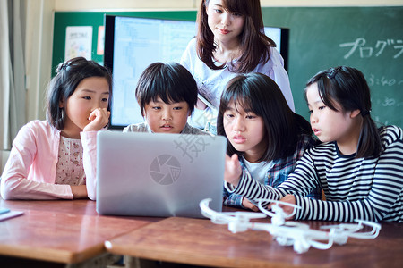 小学生在老师的指导下用电脑查询资料活力高清图片素材