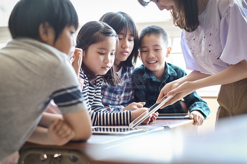 小学生在老师的指导下用电脑查询资料图片