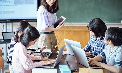 小学生在老师的指导下学习电脑使用知识微笑高清图片素材