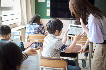 小学生在老师的指导下学习电脑使用知识上课高清图片素材