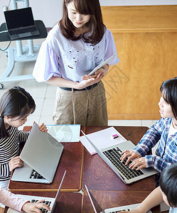 小学生在老师的指导下学习电脑使用知识女孩们高清图片素材