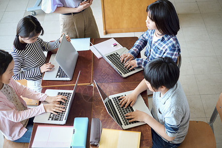 小学生在老师的指导下学习电脑使用知识上课高清图片素材