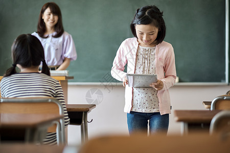 老师在教学生用平板电脑查询资料座位高清图片素材