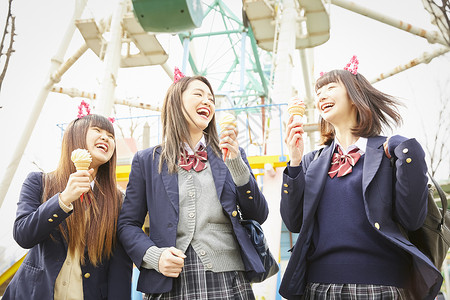 日本校服在游乐园玩耍的高中女生背景