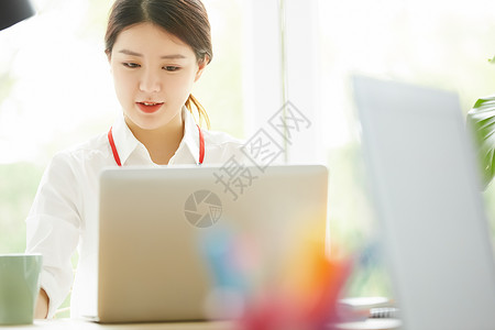 使用笔记本电脑的青年女性微笑高清图片素材