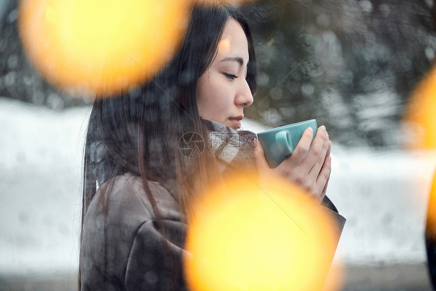 空白部分浅青年享受在雪的妇女茶时间图片