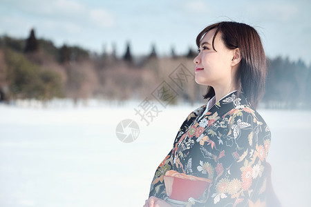 日式冬天室外站立在雪的和服妇女背景图片