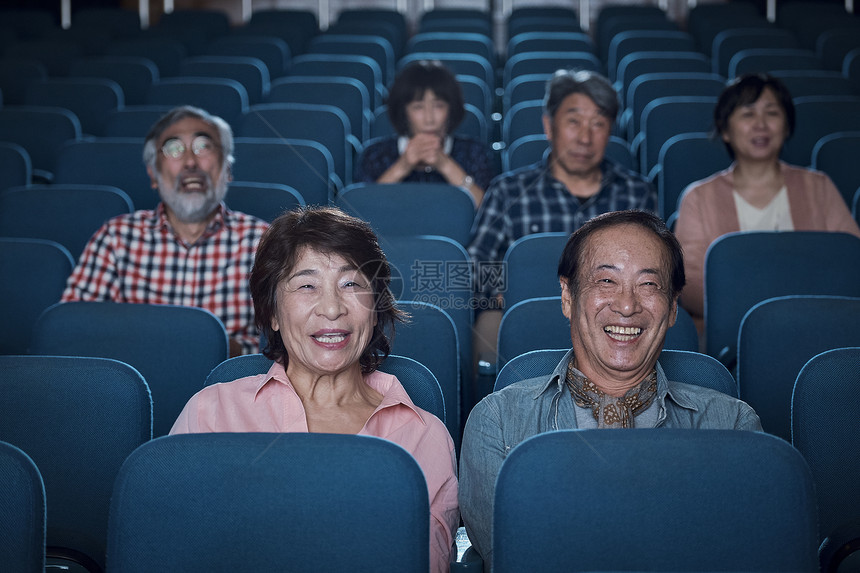 微笑男人和女人开怀笑观看电影的观众在电影院图片