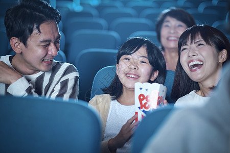 观看电影的观众在电影院笑高清图片素材
