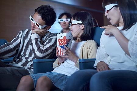 在电影院看电影的一家人休假高清图片素材