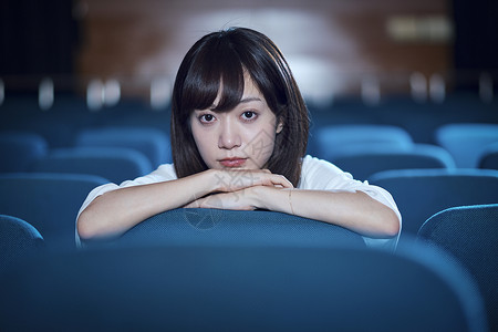 1人户内电影院坐在剧院里的女人孤独的高清图片素材