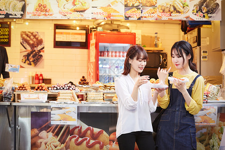 休息亲密喧闹韩国女旅游街头食品背景图片